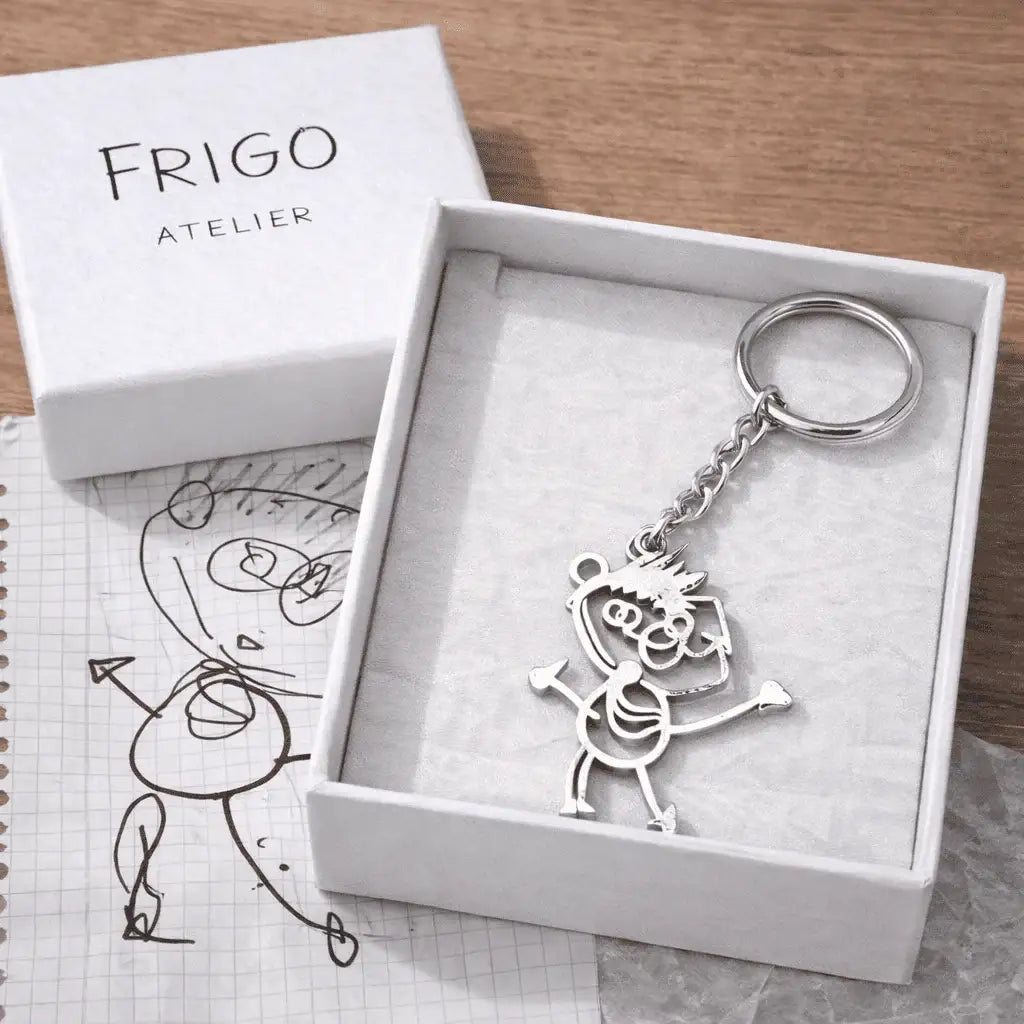 Porte-clés personnalisé en acier avec dessin d'enfant, présenté dans une boîte cadeau blanche.