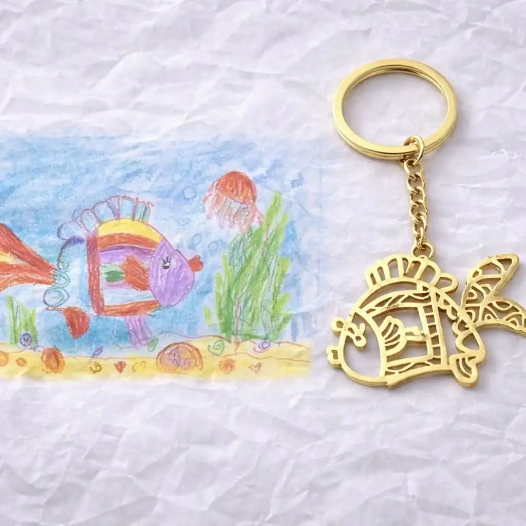 porte-clés personnalisé en métal doré reproduisant un dessin d’enfant de poisson coloré