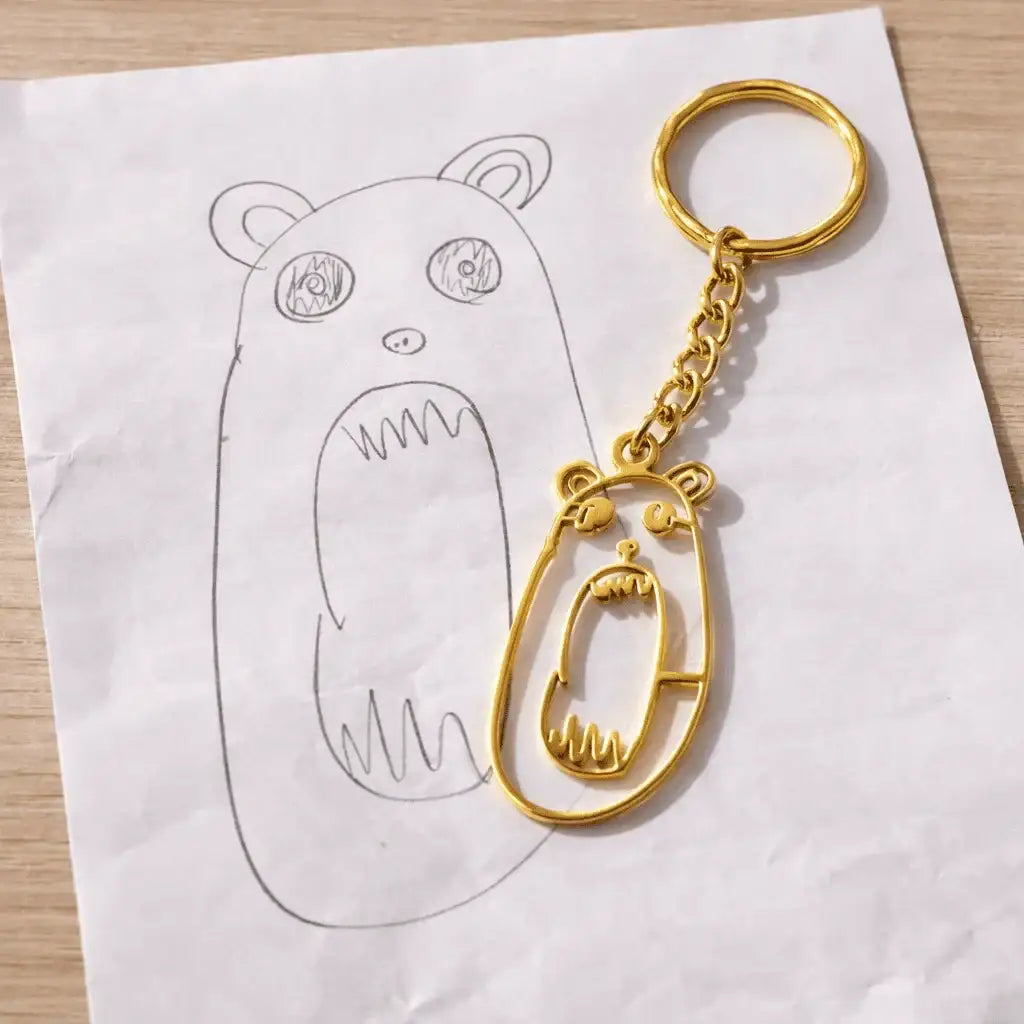 Porte-clés personnalisé en acier doré inspiré d’un dessin d’enfant représentant un ours.